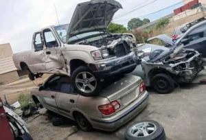 Damaged pickup truck stacked on a crushed sedan in a scrapyard, ideal for free car removal in Melbourne