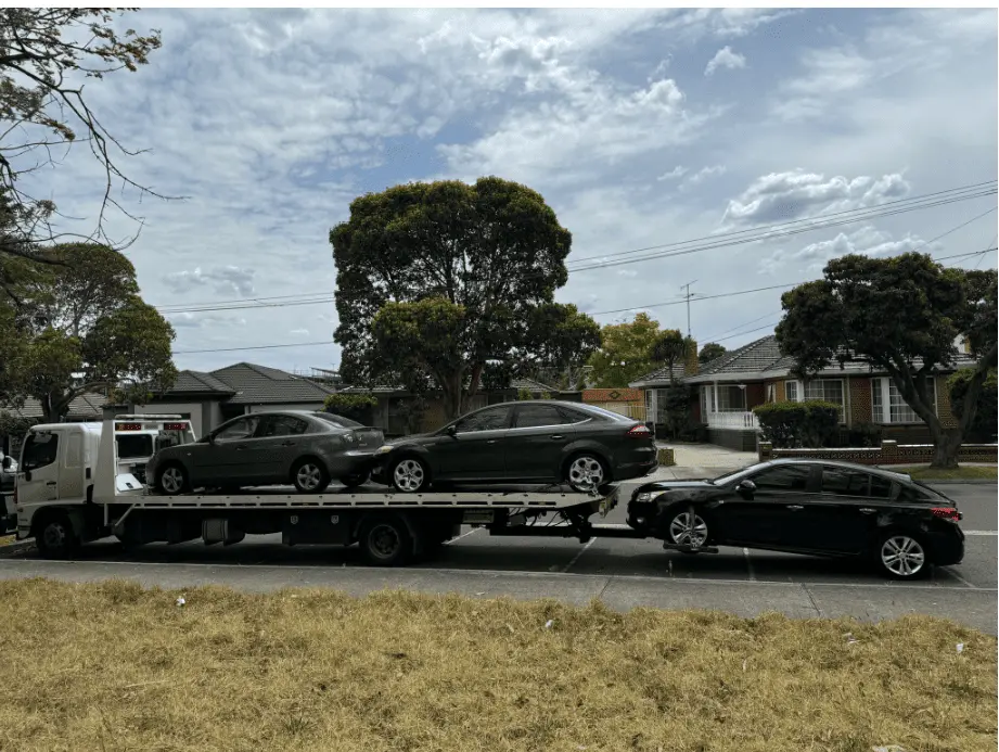 Free car removal in melbourne service transporting multiple vehicles on a flatbed truck for cash for cars