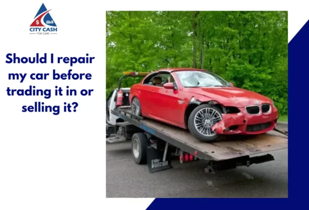 Damaged red car on a tow truck before being sold or traded in.