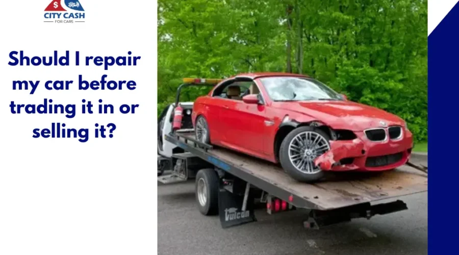 Damaged red car on a tow truck before being sold or traded in.