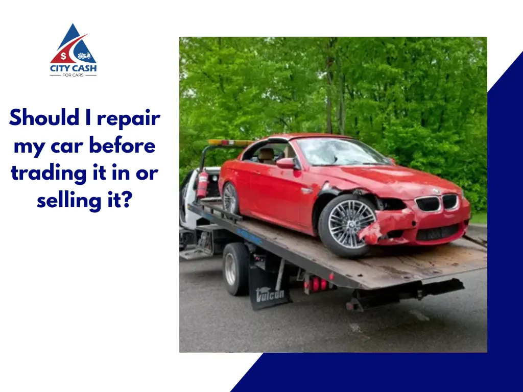 Damaged red car on a tow truck before being sold or traded in.